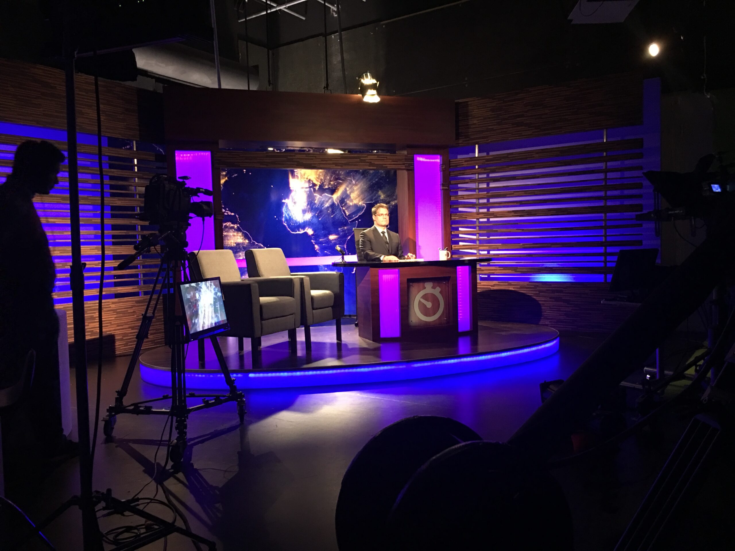 Studio setup for TVV news broadcast with Luis Chataing. In the foreground you can make out the filmcamera, and on the left another camera operator with camera