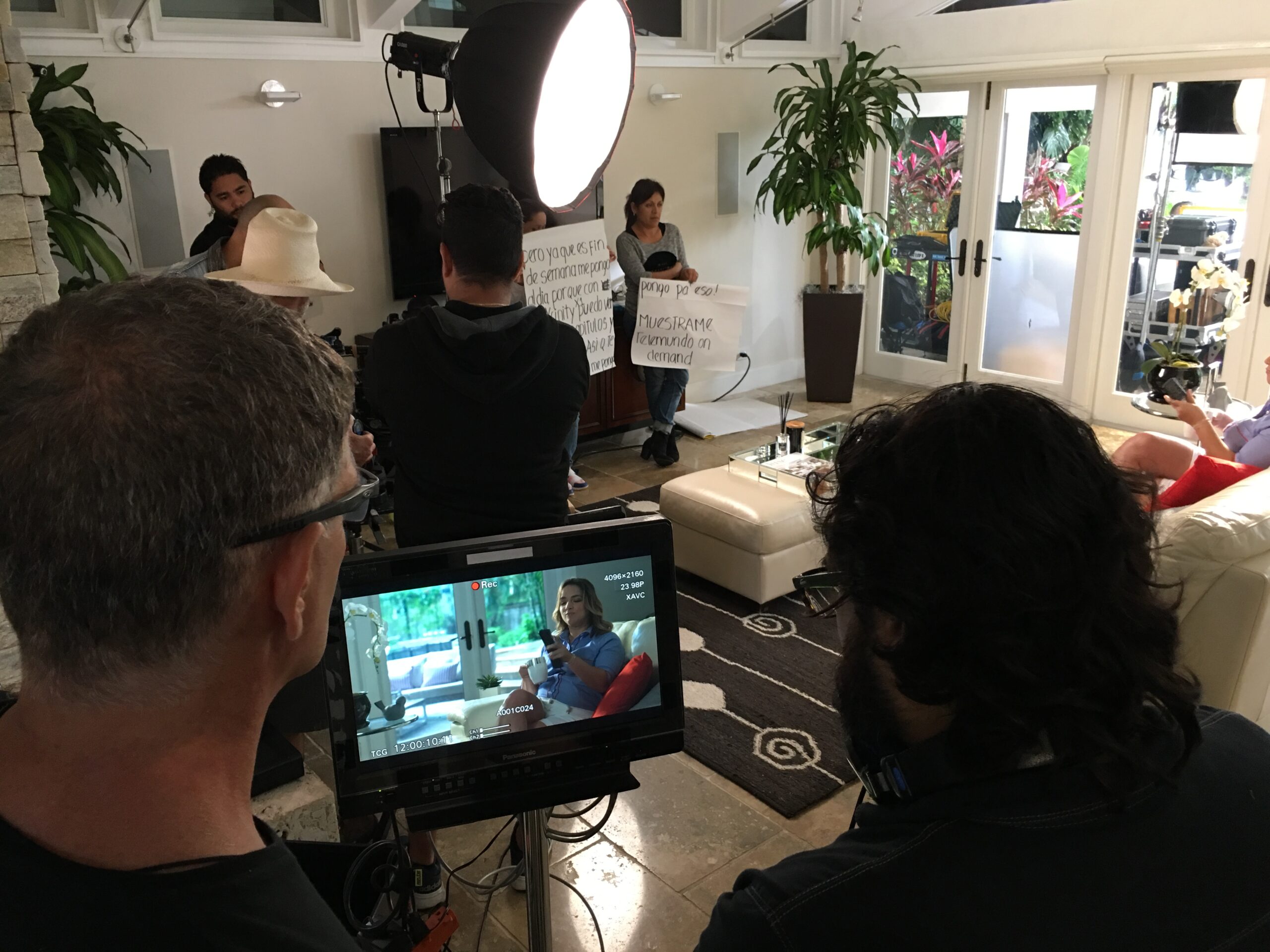 Filming in a livingroom with director Kenny O’Brian and DP Nacho Gonzales looking at the screen, a large round Chimera with LED Nanlite 720 Bi-Color illuminating the actor and 2 people in the background holding boards with text to read